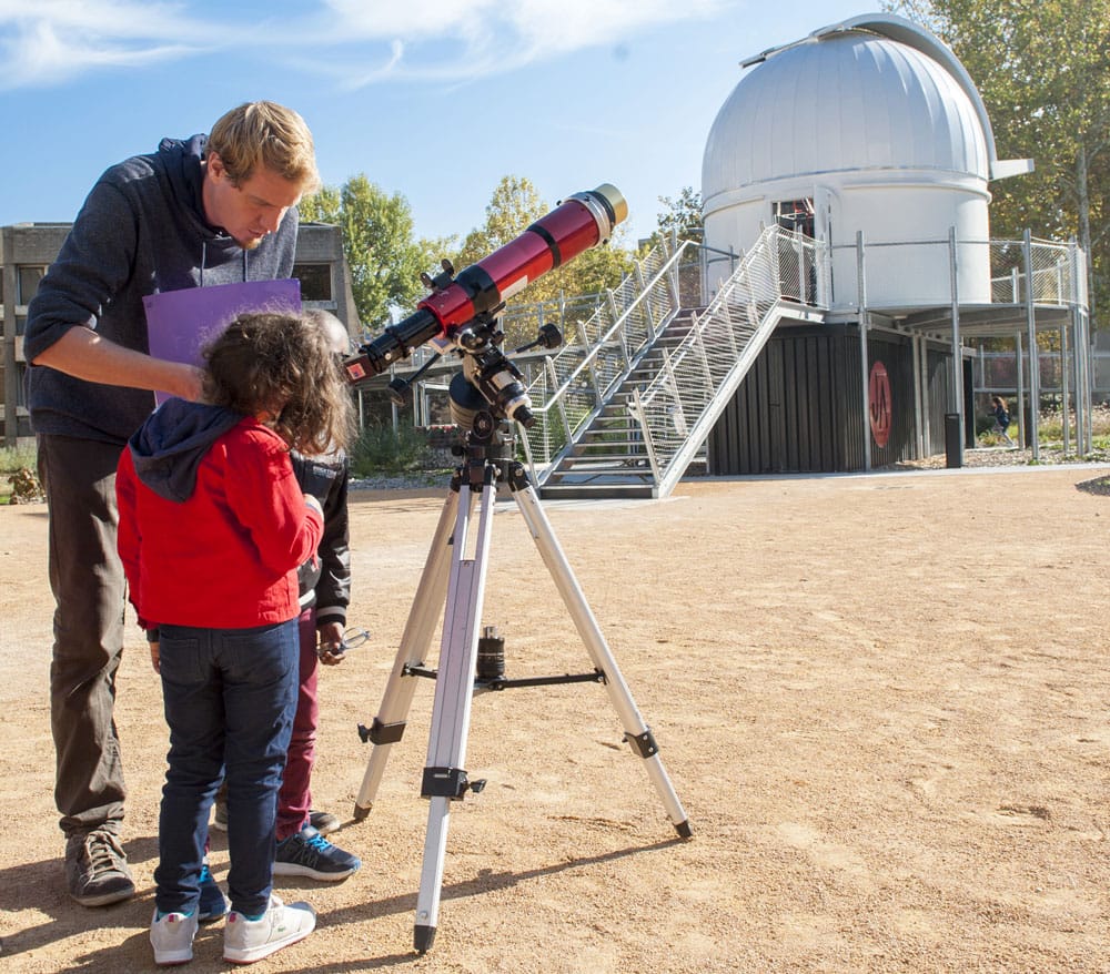 Enfants et animateur devant un téléscope